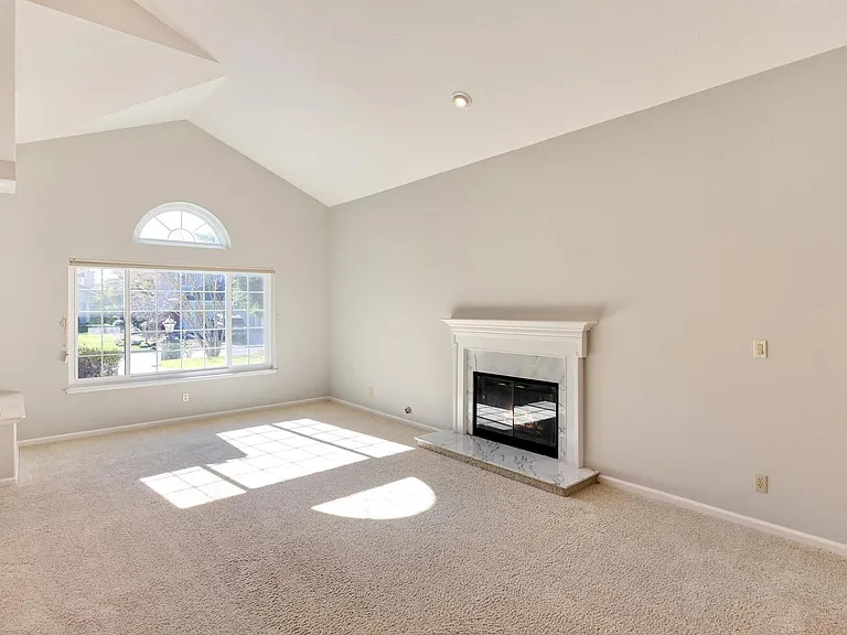 The entry welcomes you to the living room and formal dining room with volumed ceilings and a fireplace.