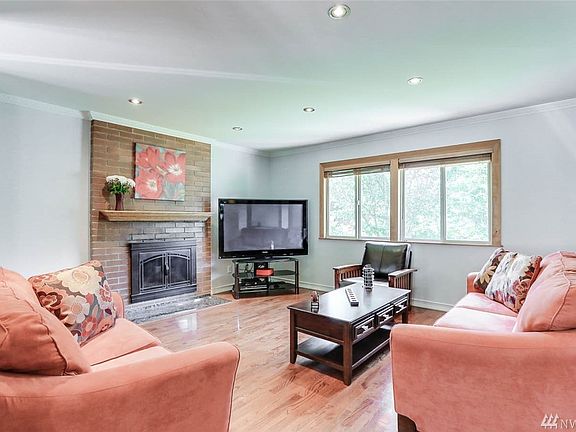The family room features a wood-burning fireplace with brick accent wall and updated lighting.