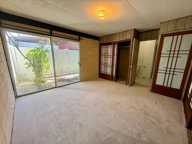 Bedroom 3 with Shoji screens and sliding glass door to the shared patio