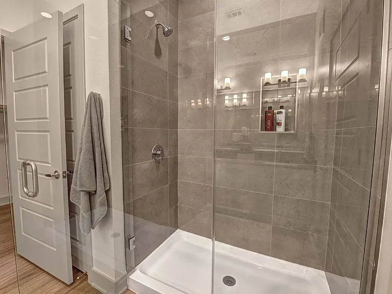 Select bathrooms include a glass-enclosed shower with custom tile surrounds.