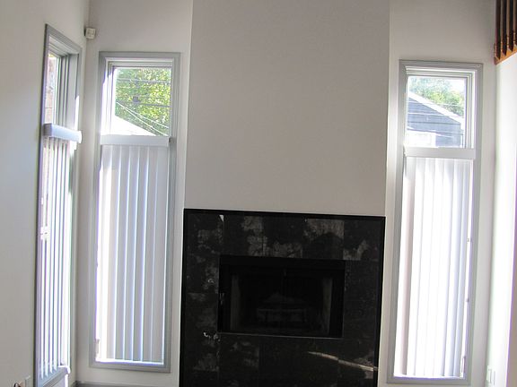Living room with vaulted ceiling and wood-burning fireplace