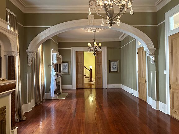 Double parlor with arched center, 2 mantles, chandeliers, cypress doors, hardwood floors, floor to ceiling windows