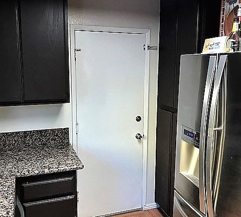 Entry to garage and laundry area. Pantry to the right of garage door and the refrigerator.