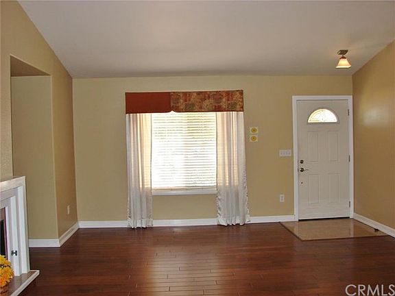 VIEW TOWARDS FRONT DOOR FROM KITCHEN. WOOD FLOORS, DRAMATIC VOLUME CEILINGS MAKE FOR FEELING OF OPENNESS AND UNCRAMPED LIVING.