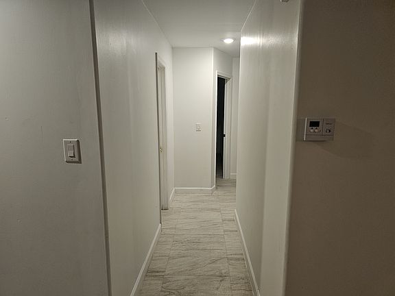 Hallway leading to three bedrooms and bathroom
