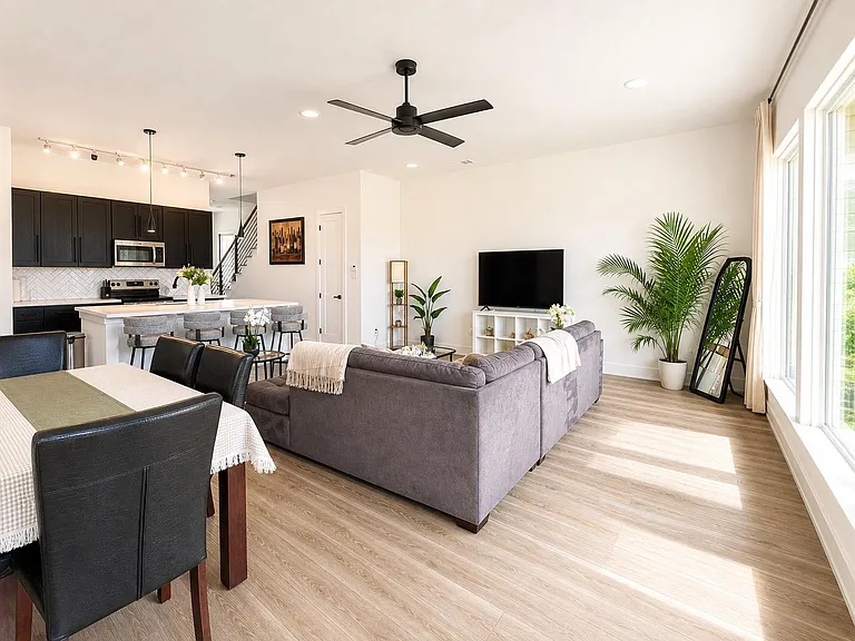 Open-concept living area connects to the kitchen with a breakfast bar, plus a dining space and large windows for natural ligh