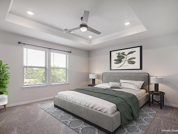 Primary bedroom boasts vaulted ceilings, oversized windows that bring in abundant natural light, and generous space to unwind.