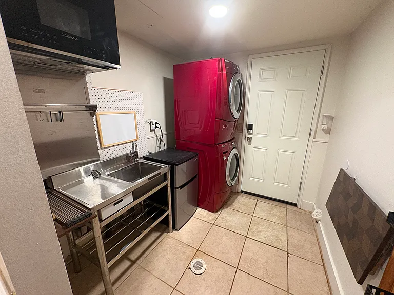 Downstairs laundry room with kitchenette (microwave, sink, and minifridge).