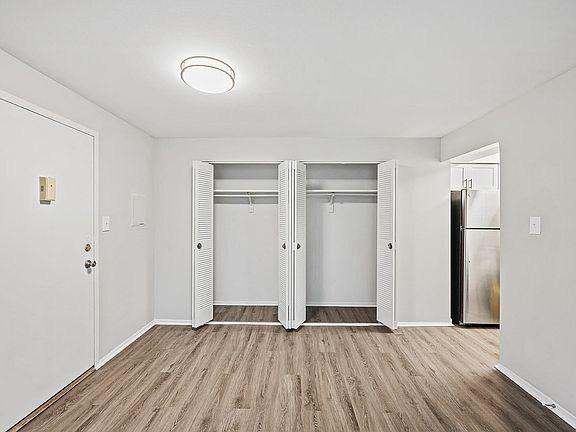 Explore modern living with this chic open closet design, complemented by elegant hardwood floors.