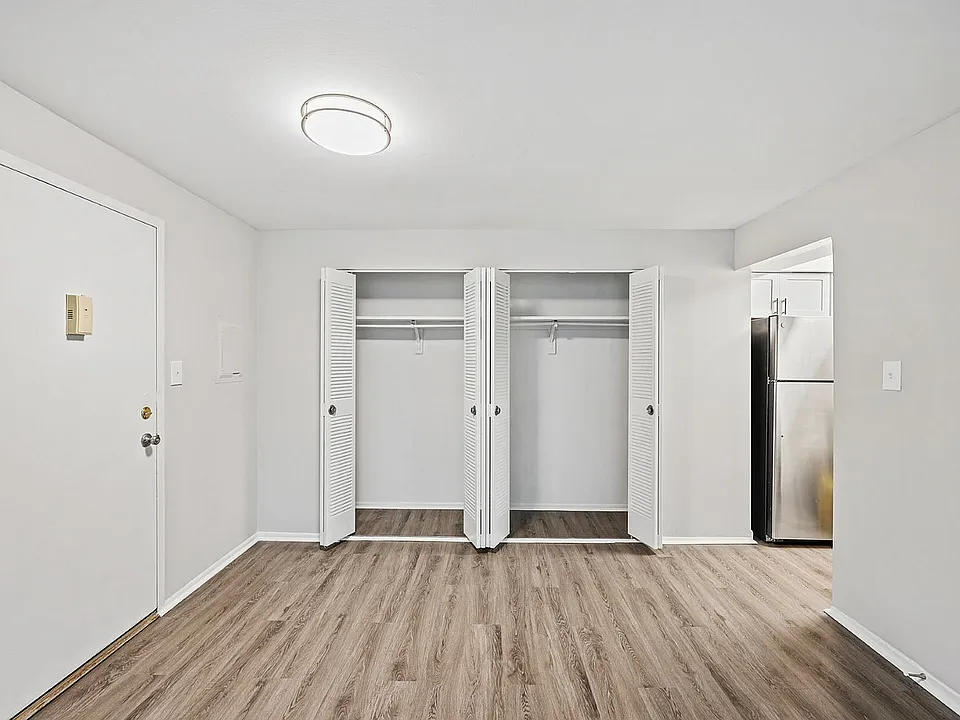 Explore modern living with this chic open closet design, complemented by elegant hardwood floors.