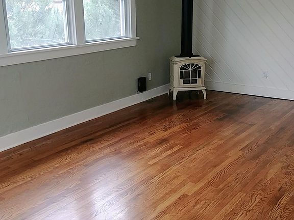 Living room area - great light, translucent insulated blinds. Gas log parlor stove. Hardwood floor. Well insulated home.