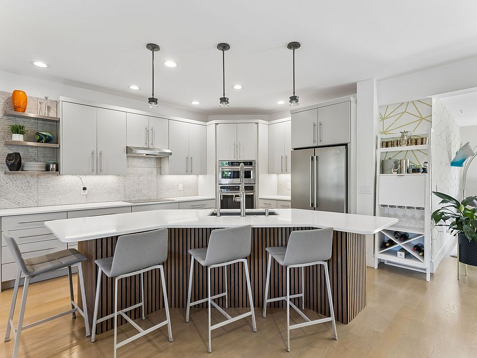 Updated kitchen featuring an oversized island with seating, quartz countertops, and stainless steel appliances