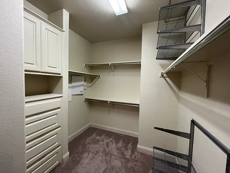 Spacious master bed closet with cabinets