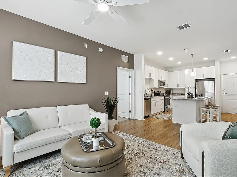 Elegant open-concept living room with cozy seating, stylish decor, and a modern kitchen island, perfect for entertaining.