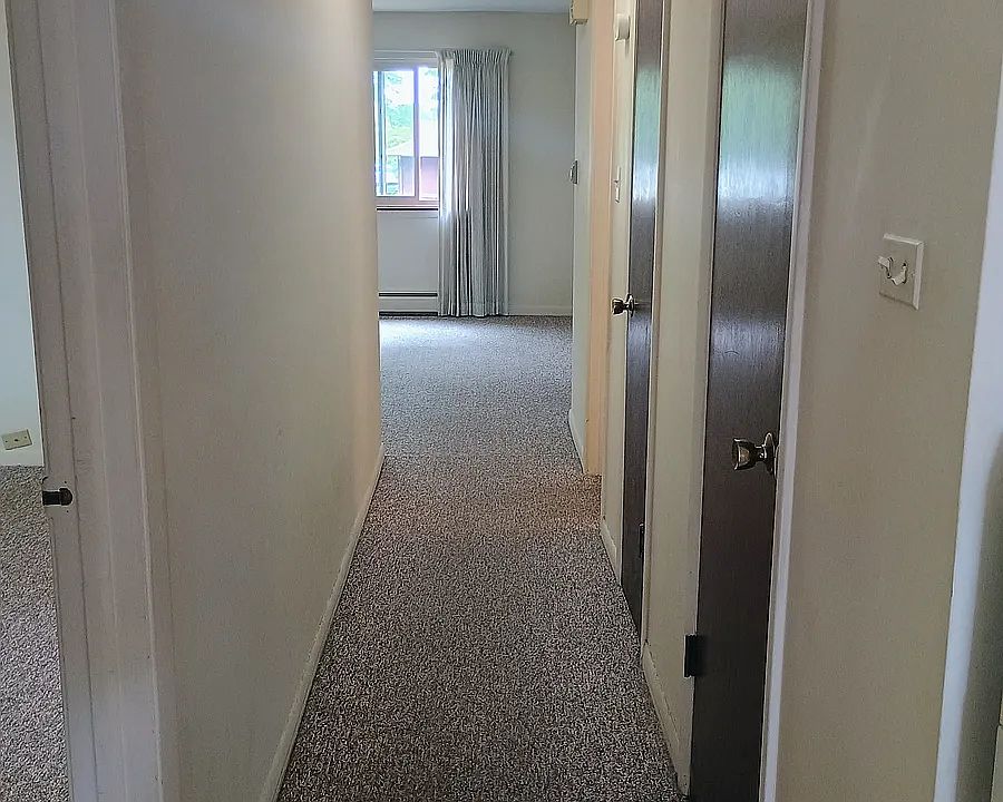 Hallway (seen from kitchen)
Second bedroom door at far left side of picture, corner beside stove on right side of picture. Doors down the hallway leading to the walk-in closet, shelved linen closet, and lastly the bathroom respectively.
