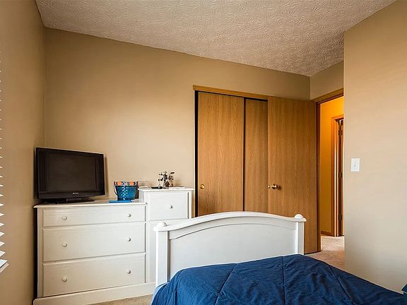Comfortable bedroom with neutral walls, ample space, and closet storage.