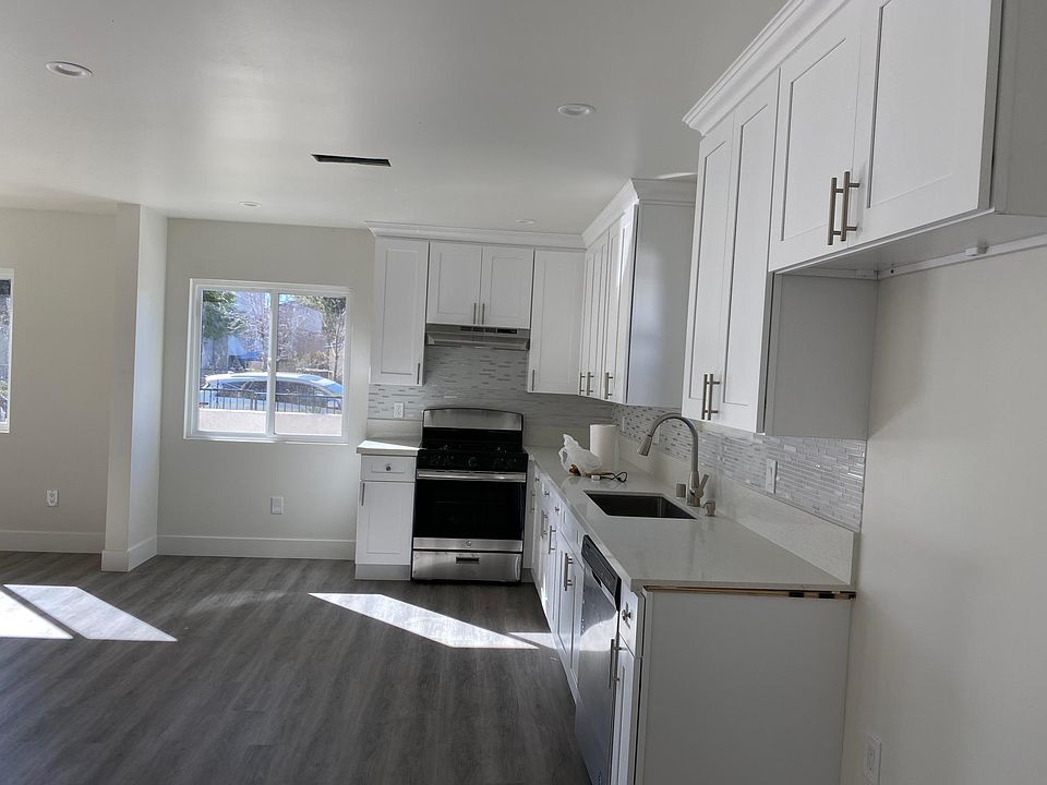 Quartz countertops, white shaker cabinets, glass custom backsplash, and big farm sink.