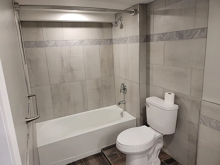 Main bathroom, tub and shower with curved double shower rod