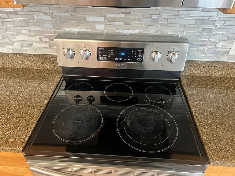 26 - Smooth-top range with easy-clean surface and tile backsplash.