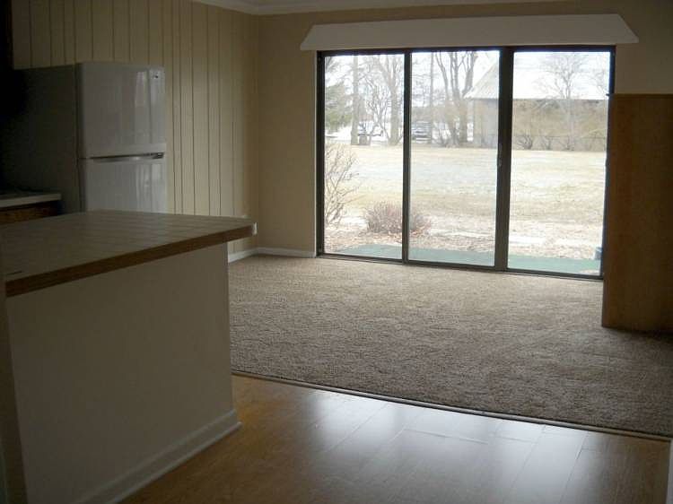 Large living room w/patio door overlooks former tennis courts.