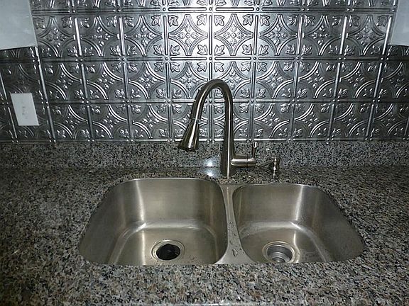 Granite counters with under mount sink and beautiful back splash
