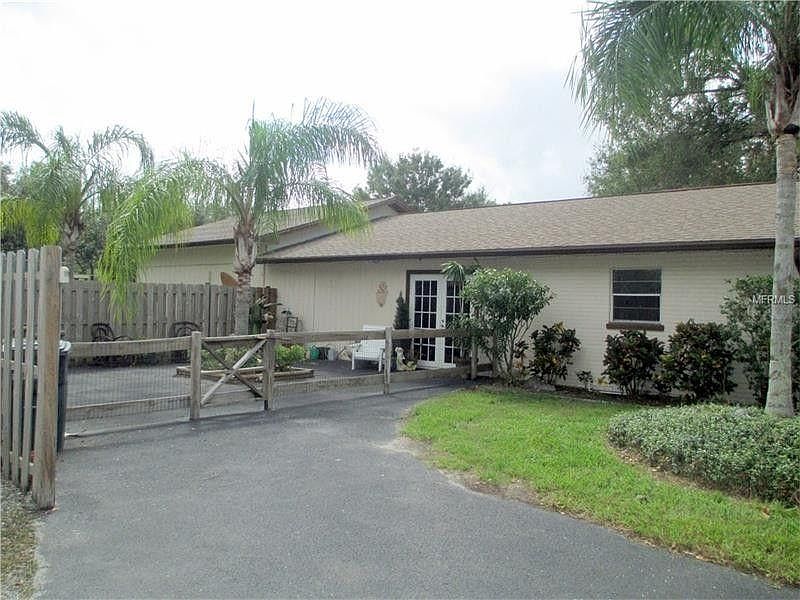 Front of home with private fenced courtyard.