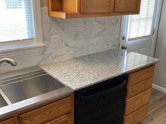kitchen with vinyl slab flooring and beautiful cabinets. Additial sink in the large laundry room
