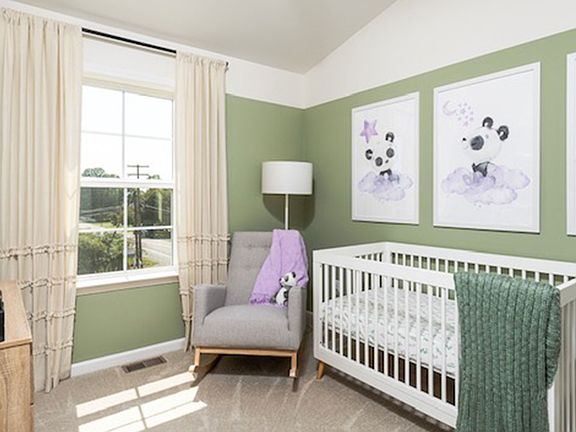 Carpeted secondary bedroom with large window in a DRB Homes York II Garage Model.