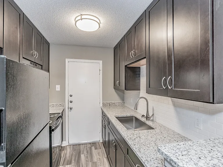 Enjoy cooking in stylish kitchens with dark cabinetry and granite-style counters at Chapel Creek Apartments.