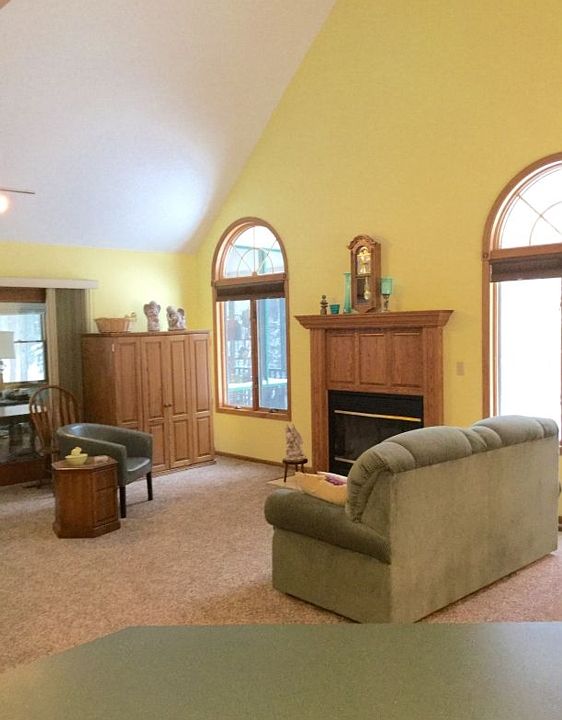 View of the vaulted living room with gas-log fireplace - open and spacious from the kitchen as well - all carpeting is neutral and brand new!