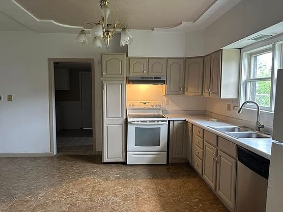This mid-century chic kitchen offers plenty of cabinet space, with a double sink and a window that lets in plenty of natural light. This is a home cook's dream, with a dining room area.