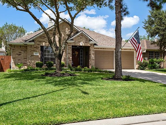 A step back from the home provides a full view of it's beautiful curb appeal. Mature trees give an abundance of shade to the lush & well manicured landscaping. Freshly power washed & painted trim are the cherry on top!