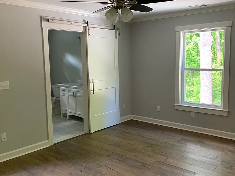 Primary Bedroom with wood floors and attached bathroom.