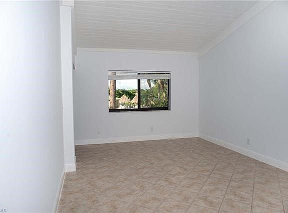 Great room in condo with tile on the diagonal and cathedral ceilings.
