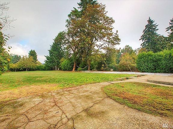 Huge, fenced and private back yard with two apple trees in the back framing the view of downtown Seattle & the Space Needle.  This yard has space to entertain, build, or just hang your hammock and enjoy.  The possibilities are endless.