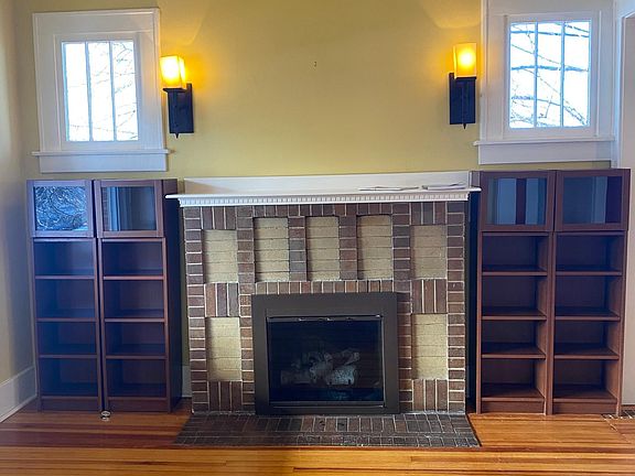 Classic Craftsman style fireplace with original brickwork, gas inserts, balanced bookshelves, windows and lighting
