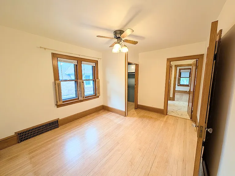 [UPPER UNIT]: First bedroom with shutter style window covers and blinds. Double sized closet