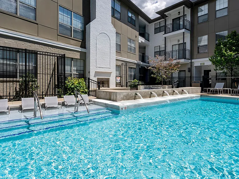 Resort style pool with tanning ledge and water feature