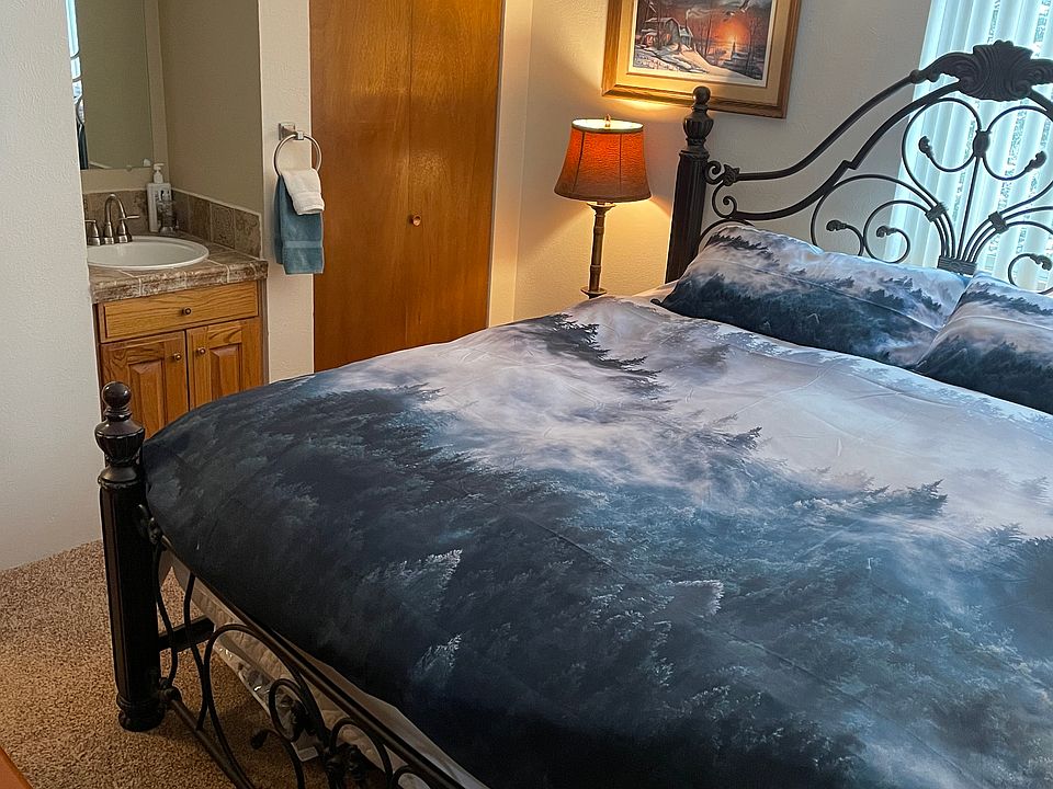 Master bedroom with a king bed, sink, watercloset, shower and television.