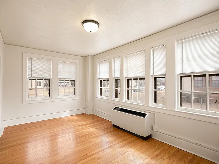 Bright, Spacious Sunroom with wood flooring.
