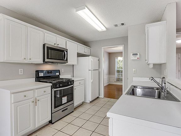 Crisp white kitchen with new SS appliances