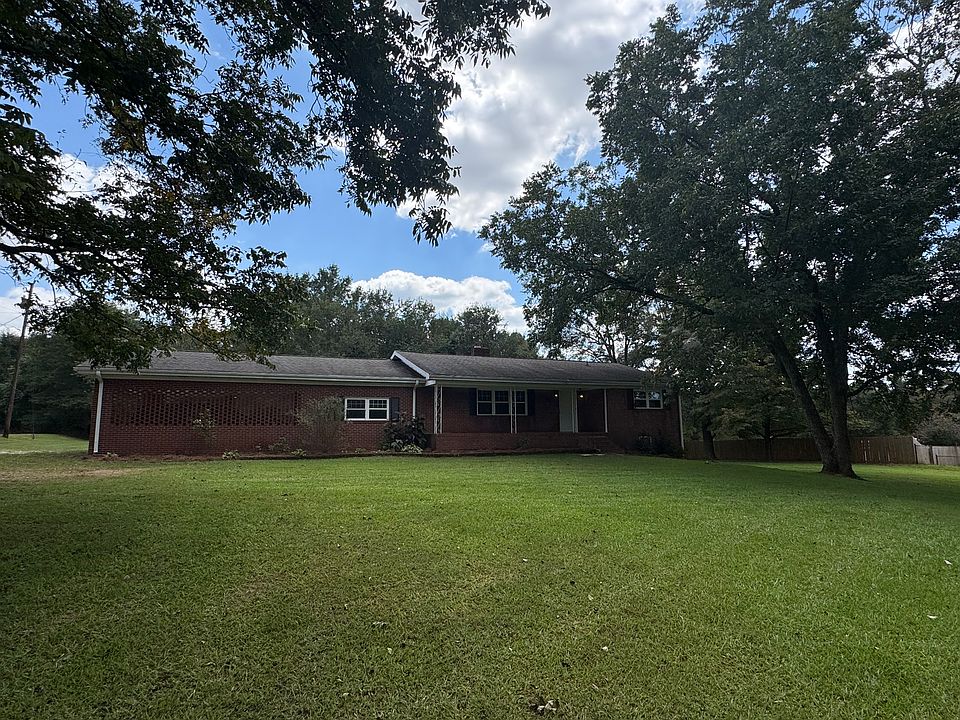 Your new home that sits on 3 acres of wooded back yard . Cozy private brick ranch totally remodeled with front porch and covered attached carport that has concrete floor large enough to fit 2 trucks or suvs.