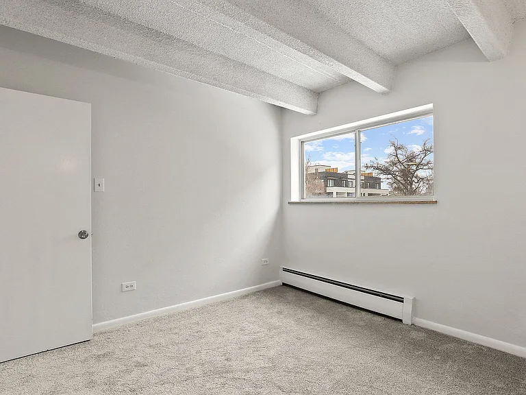 Bright and airy room with large window offering scenic outside views, perfect for peaceful living.