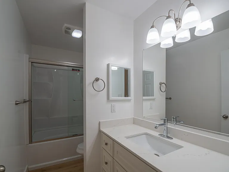 Front bedroom's bathroom w/linen closet and all new vanity, shower insert and tub, sliding glass doors, toilet, fixtures, etc