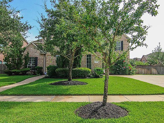 Beautiful brick elevation with shutters and mature landscaping.