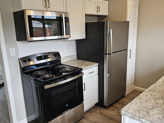 Kitchen features stainless steel appliances and subway tile backsplash.
