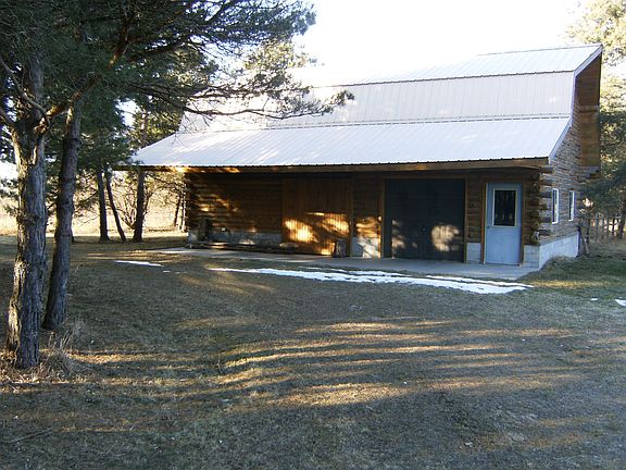 Front view of large garge with metal roof and covered front full length 