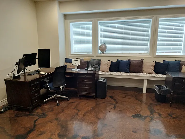 This spacious office boasts 10-foot basement ceilings, large windows for natural light, and two desks equipped with monitors and outlets for teleworking. Enjoy a treadmill for break-time exercise and a cozy fireplace to keep you comfortable.