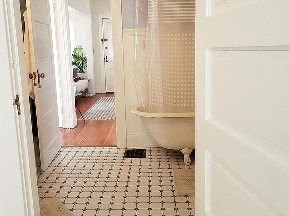 Charming, large bathroom features clawfoot tub and tiled floor.