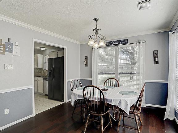 The dining room is conveniently located near the kitchen, it has a newly updated light fixture and ample natural lighting.